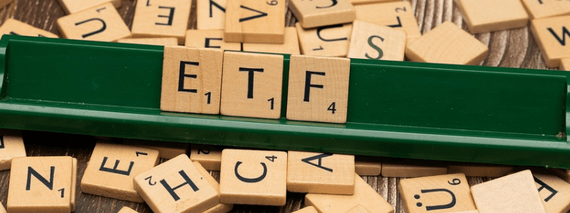 Scrabble-Steine mit dem Wort ETF in einem grünen Halter. Symbolbild für Investieren und den Artikel "Was ist ein ETF?"