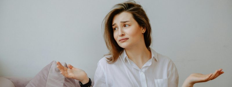 Finanzieller Stillstand: Frau mit ausgebreiteten Armen ist ratlos